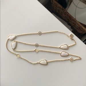 long necklace with white stones and logo